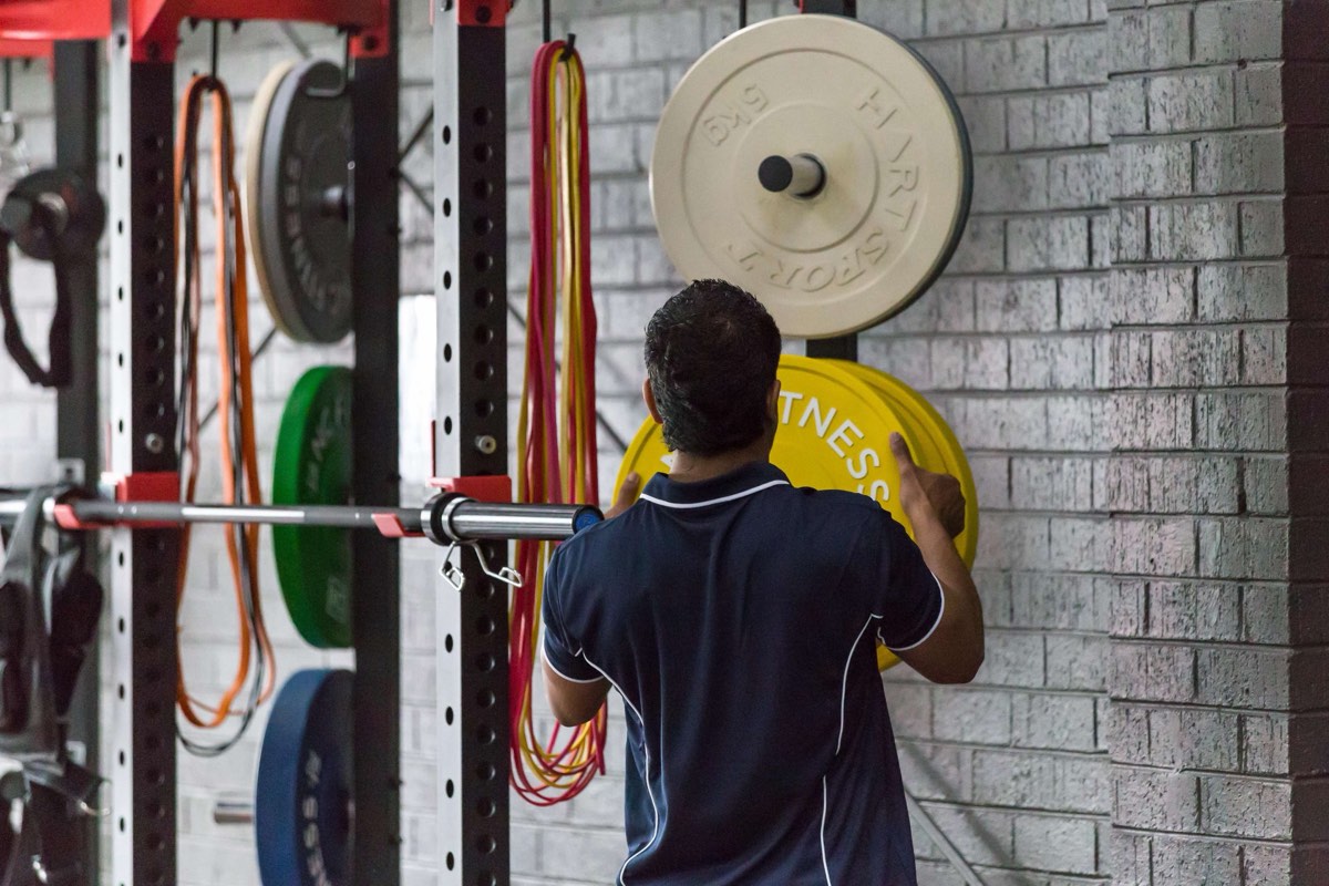 ACFB trainers taking a client through a fitness assessment